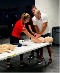 Two individuals demonstrating CPR techniques together.